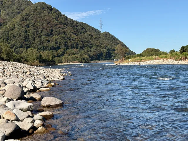 礫の岸と鉄塔のある山
